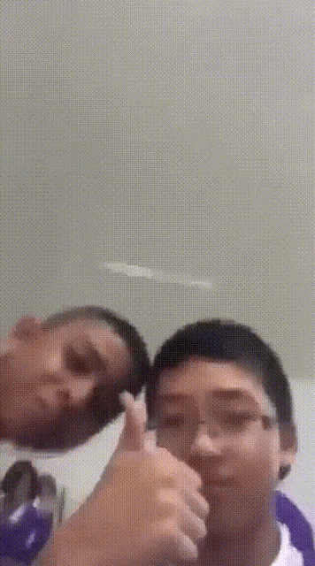 a boy giving a thumbs up next to a woman