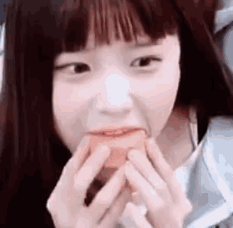 a close up of a girl eating a piece of food .