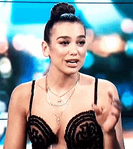 a woman wearing a bra and a necklace is talking to someone .