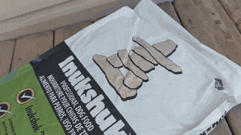 a bag of inukshuk professional dog food sits on a wooden surface