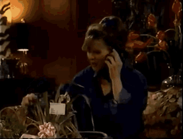 a woman sitting on a couch talking on a phone