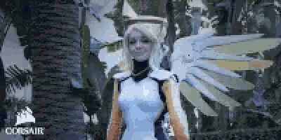 a woman in a cosplay costume with angel wings is standing in front of a palm tree .