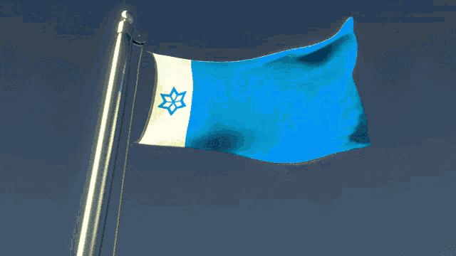 a blue and white flag with a star on it is flying in the wind