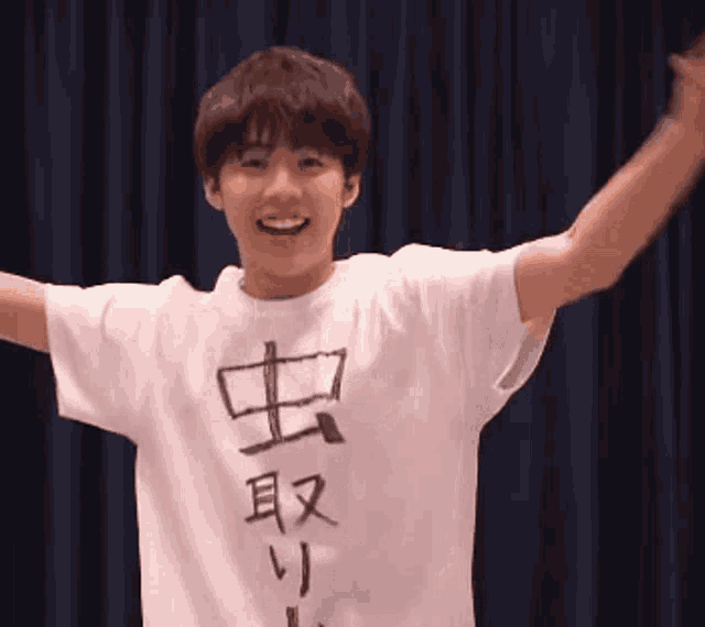 a young man wearing a white shirt with chinese characters on it