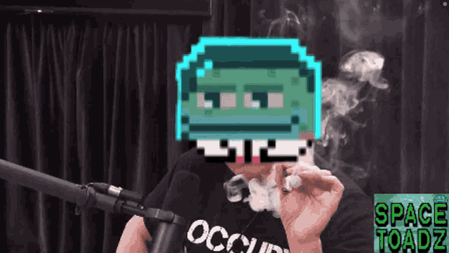 a man smoking a cigarette in front of a microphone with a space toadz logo in the corner