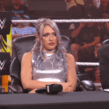 a woman sitting in a chair with a microphone that says nxt on it