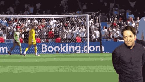 a man stands in front of a booking.com ad