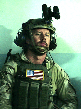 a man wearing a helmet and a vest with an american flag patch