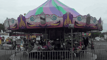 a merry go round at a carnival with people riding it