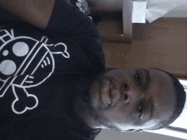 a man wearing a black shirt with a skull on it