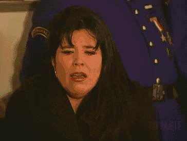 a woman with a ring on her finger is crying in front of a police uniform