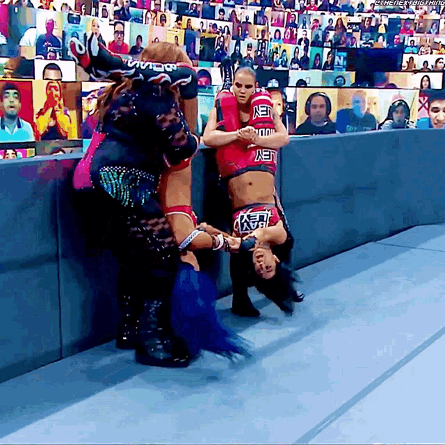 a female wrestler wearing a red jersey that says net on it