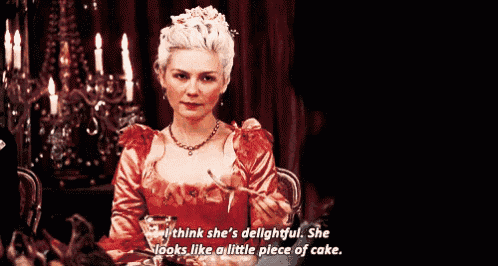 a woman in a red dress is sitting at a table with a fork in her hand and says she 's delightful