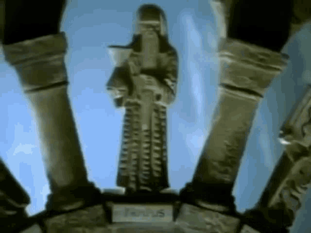 a statue of a man holding a sword is surrounded by columns and a blue sky .