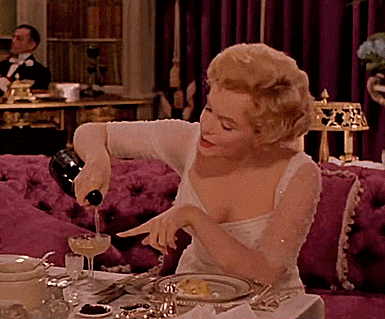 a woman is pouring wine into a glass