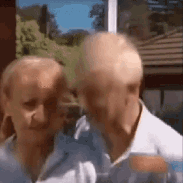 a man and a woman are standing next to each other and looking at each other in a blurry photo .
