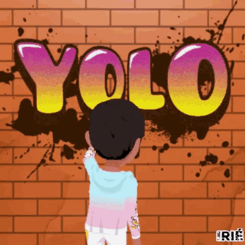 a boy is standing in front of a brick wall that has the word yolo painted on it