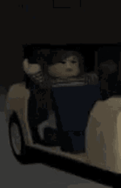 a doll is sitting in a car with the door open and looking out the window .