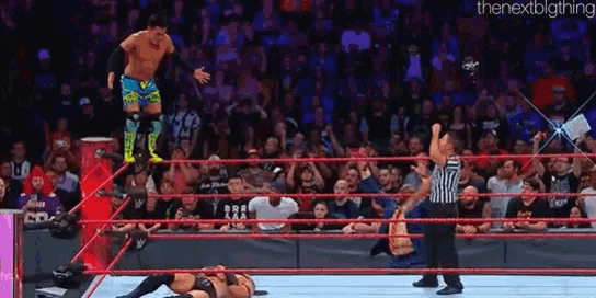 a wrestler is jumping over another wrestler in a wrestling ring during a match .