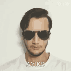 a man wearing sunglasses and a white shirt says ayiks
