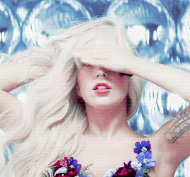 a woman with a tattoo on her arm covering her eyes