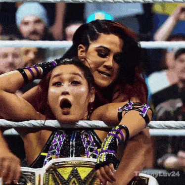 two women in a wrestling ring with the number 24 on the bottom right corner