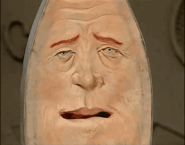 a statue of an egg with a sad look on it 's face