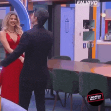 a woman in a red dress is dancing with a man in a suit