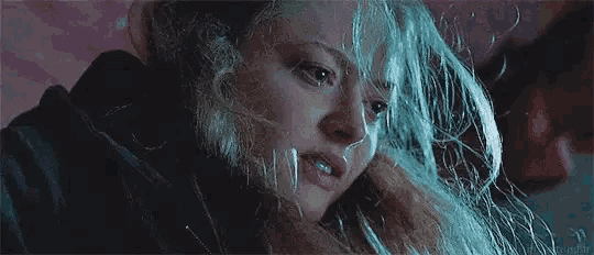 a close up of a woman 's face with a lot of hair coming out of it .