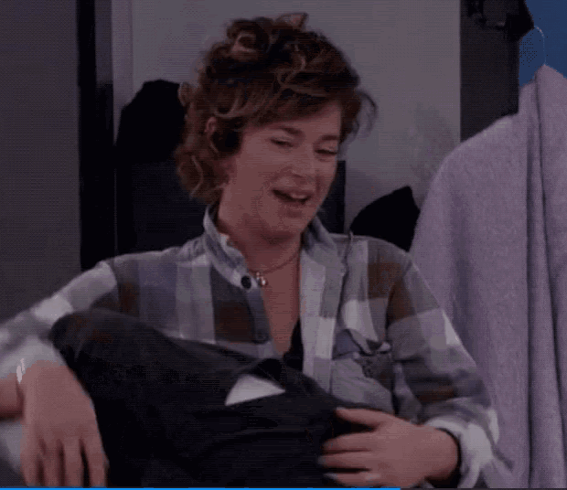a woman in a plaid shirt is smiling while holding a phone