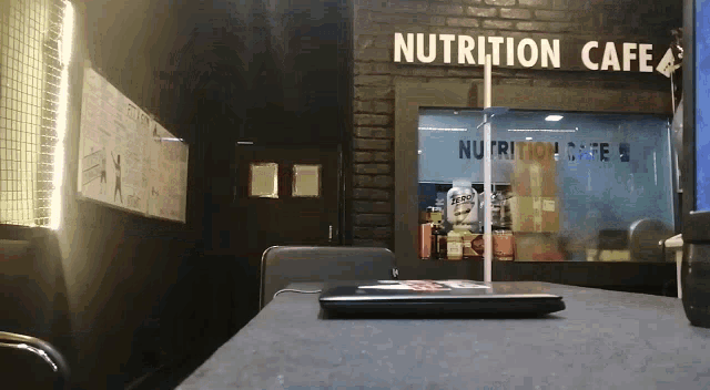 a laptop sits on a table in front of a sign that says nutrition cafe