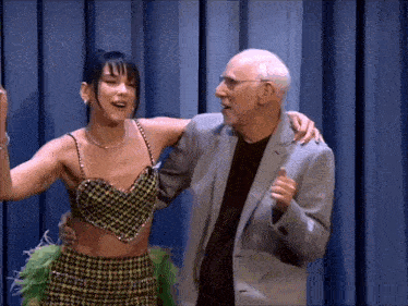 a man in a suit holds a woman in a plaid top