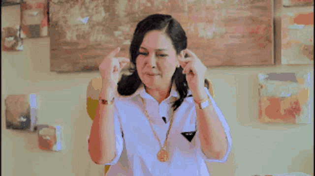 a woman in a white shirt is making a fighting sign with her hands