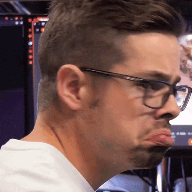 a man wearing glasses makes a funny face with his mouth open