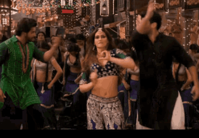 a man in a green shirt is dancing with a woman in a blue top