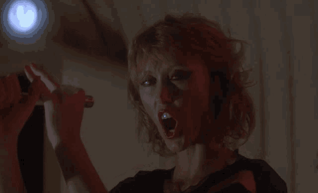 a woman in a black shirt is holding a lighter in her mouth
