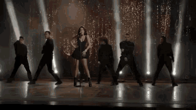 a man is touching a woman 's shoulder while dancing .