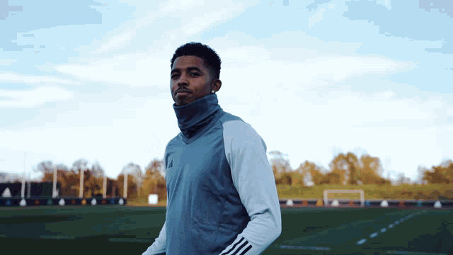 a man wearing a blue and white adidas jacket