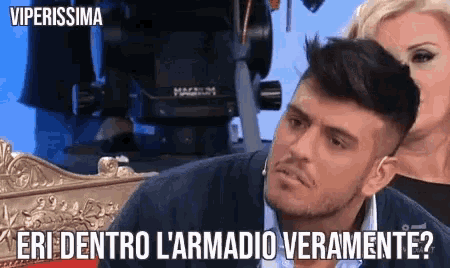 a man is sitting in front of a woman and says " eri dentro l'armadio veramente " ..