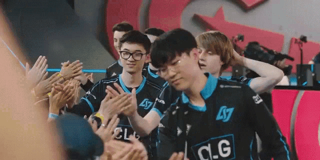 a group of young men wearing c.g jerseys are clapping