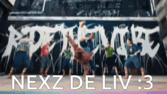 a group of people are doing a handstand in front of a sign that says nexz de liv : 3