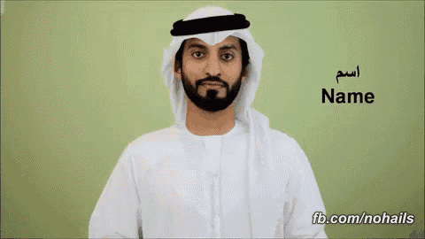 a man with a beard is wearing a white shirt and a white head scarf and has the word name written on his shirt