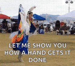 a woman in a native american dress is dancing in a field .