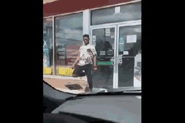 a man is standing in front of a store with a bottle of soda in his hand .