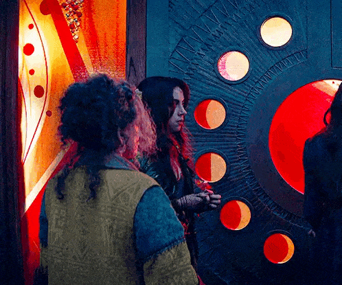 a man and a woman are standing next to each other in front of a door with circles in it .
