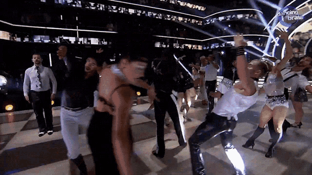 a group of people are dancing on a stage with a sign that says dancing brasil