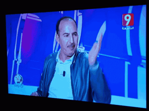 a television screen shows a man on a show with the number 9 in the corner