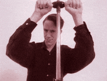 a man in a black shirt is holding a metal object