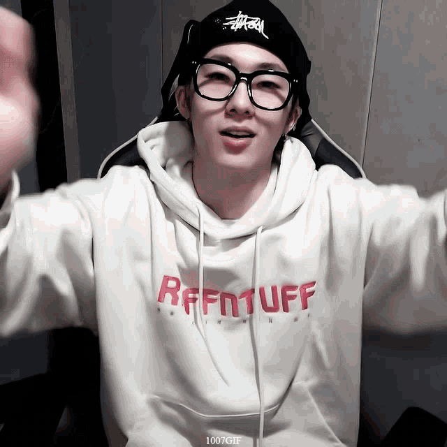 a man wearing glasses and a sweatshirt that says refintuff