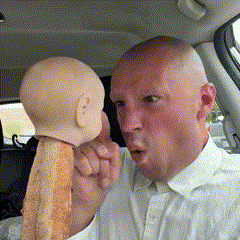 a bald man in a white shirt is holding a piece of bread